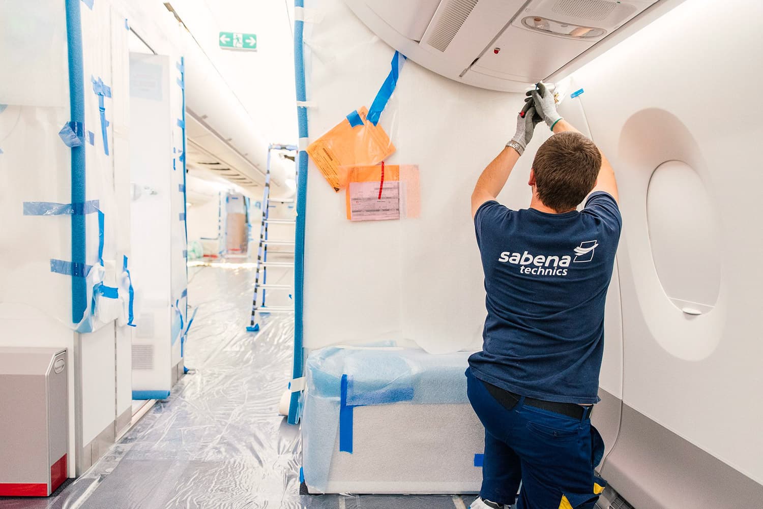 Technicien Sabena technics intervenant sur l’aménagement intérieur d’un A350 pour la compagnie French Bee, dans une cabine protégée en phase de transformation