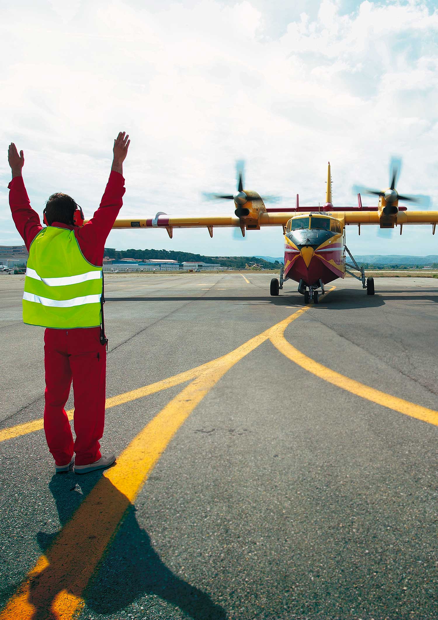 Agent de la Sécurité civile guidant un Canadair CL-415 sur le tarmac