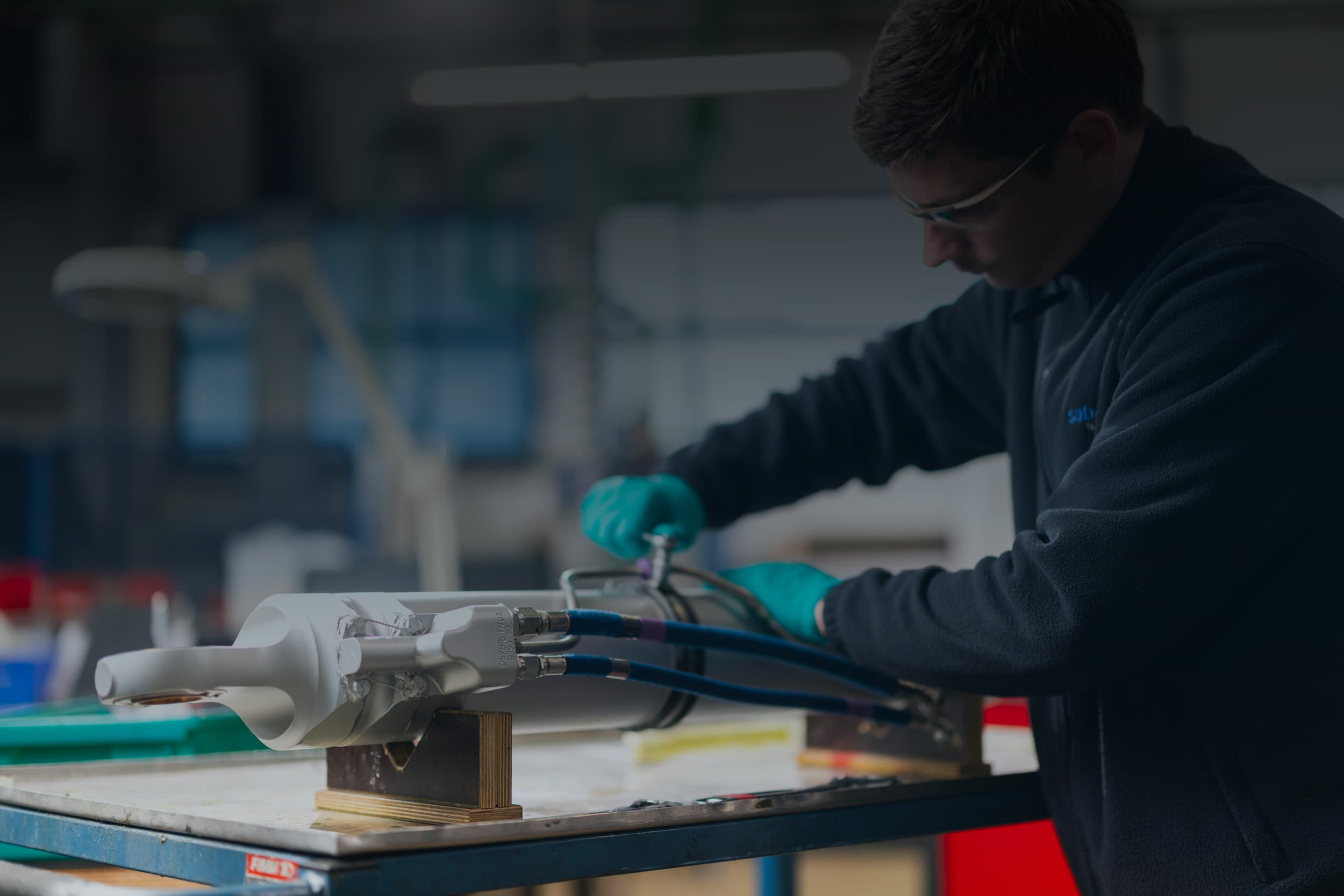Sabena technics mechanic working on a hydraulic component in the workshop